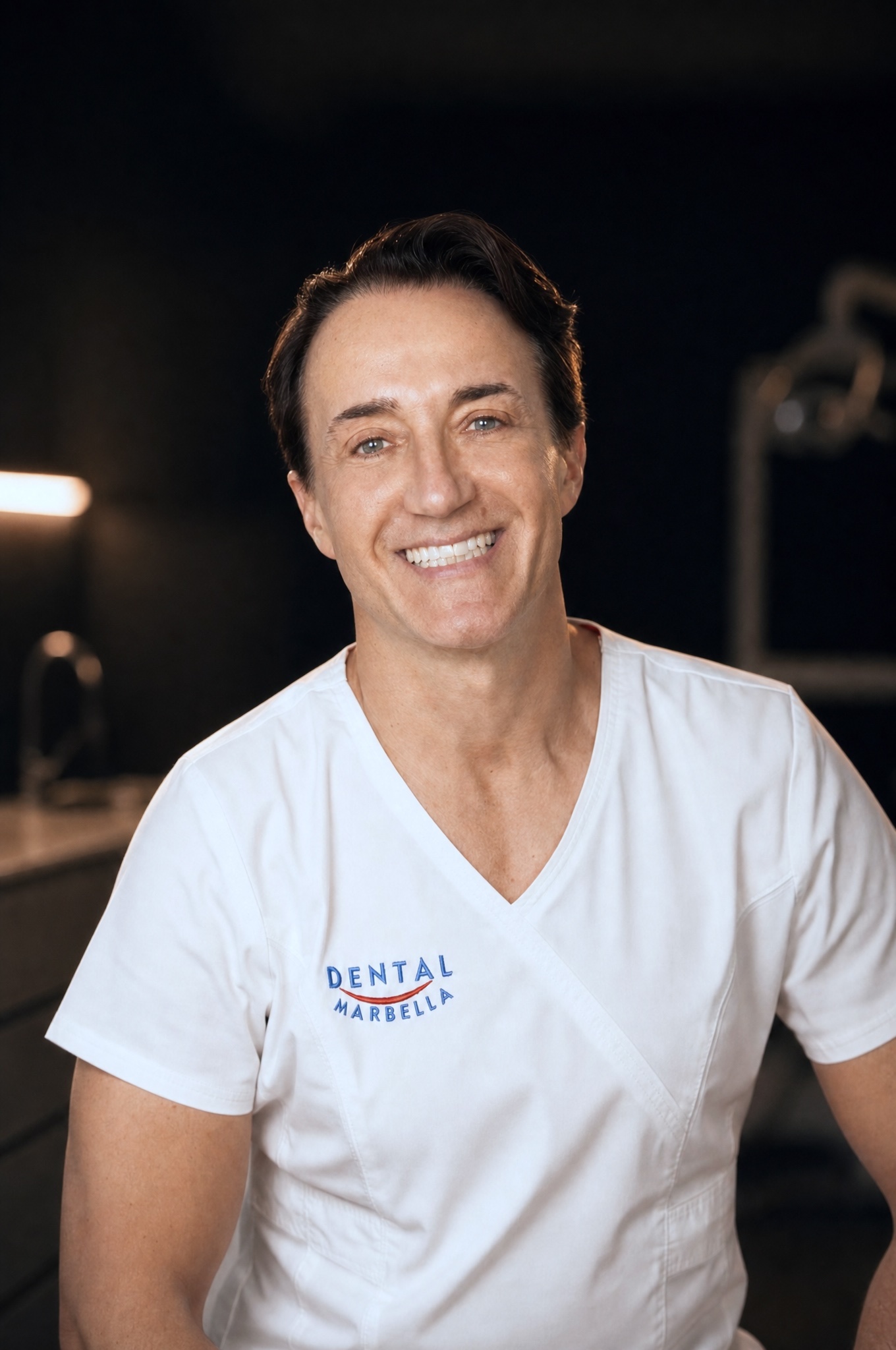 Dr. Sorin of Dental Marbella in his white clinic scrubs, warm cinematic portrait